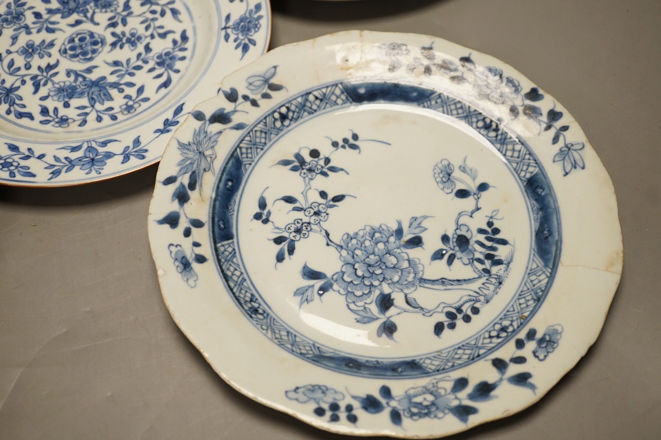 Four Chinese 18th century plates and a late 19th century blue and white dragon plate, largest 24cm diameter